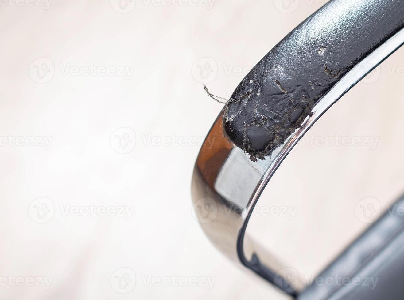 Torn and battered leather on a black office computer chair. Restoration and restoration of the leather, copy space photo