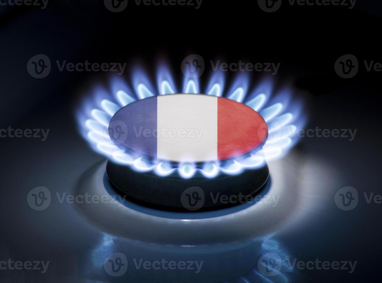 Burning gas burner of a home stove in the middle of which is the flag of the country of France. Gas import and export delivery concept, price per cubic meter, transit, background photo