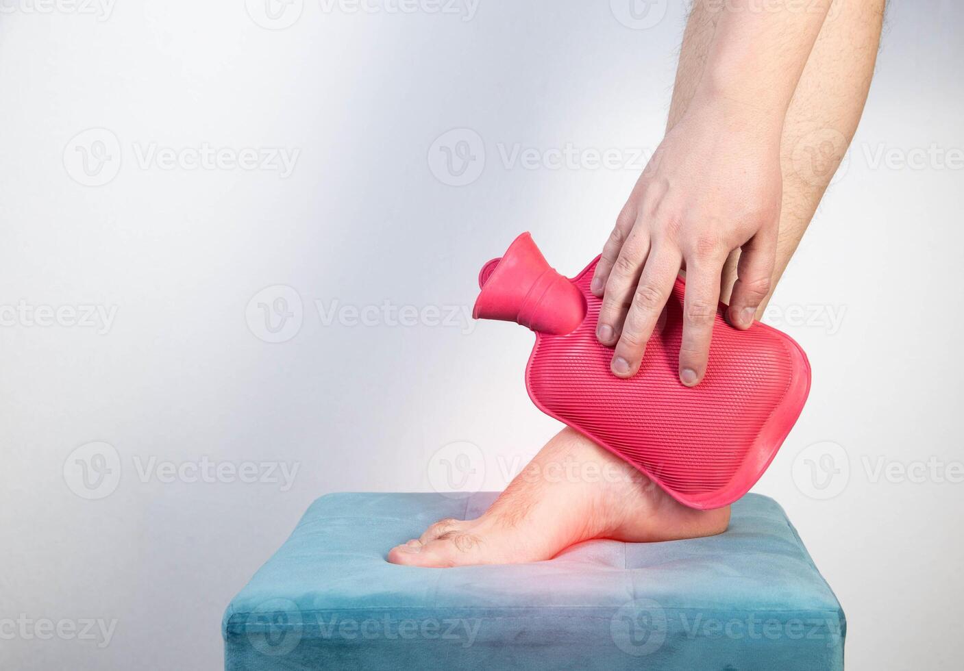 Treatment of arthritis of the ankle joint with a heating pad with hot water. Copy space for text photo