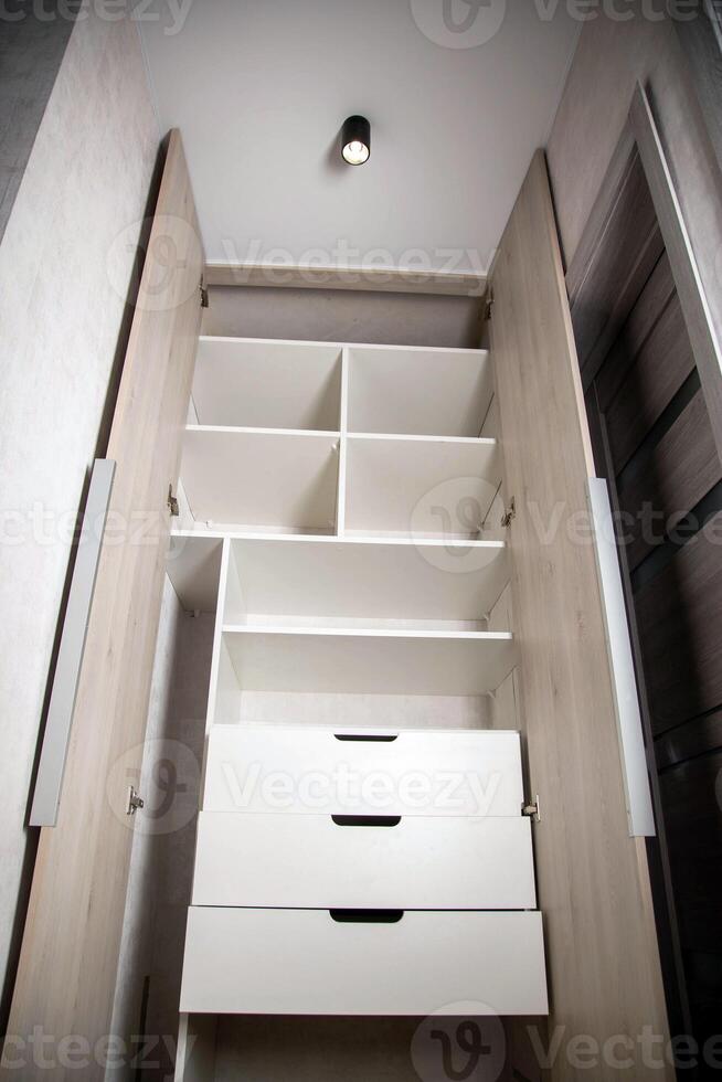 Modern closet in the hallway with hinged doors and pull-out shelves. Production of furniture under the order. photo