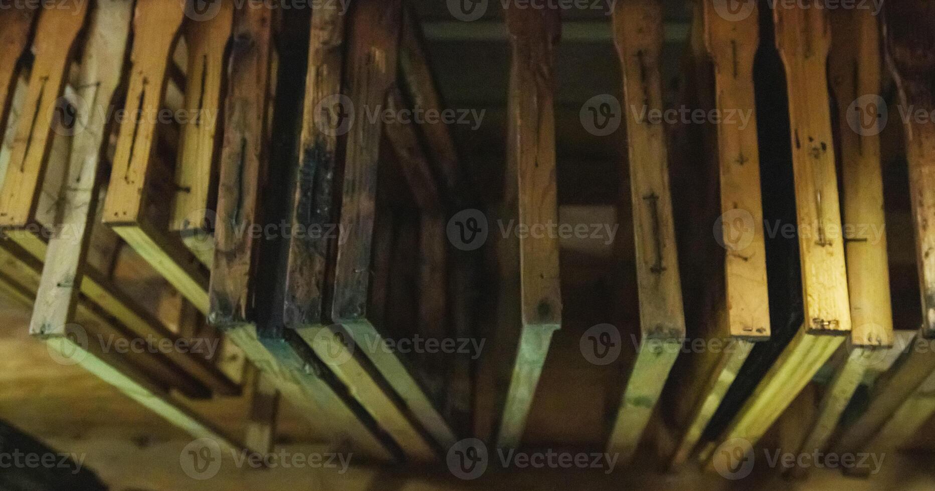 Bee frames with sealed combs and honey hang in the shed. Breeding bees, beekeeping, honey extraction, indusrty photo