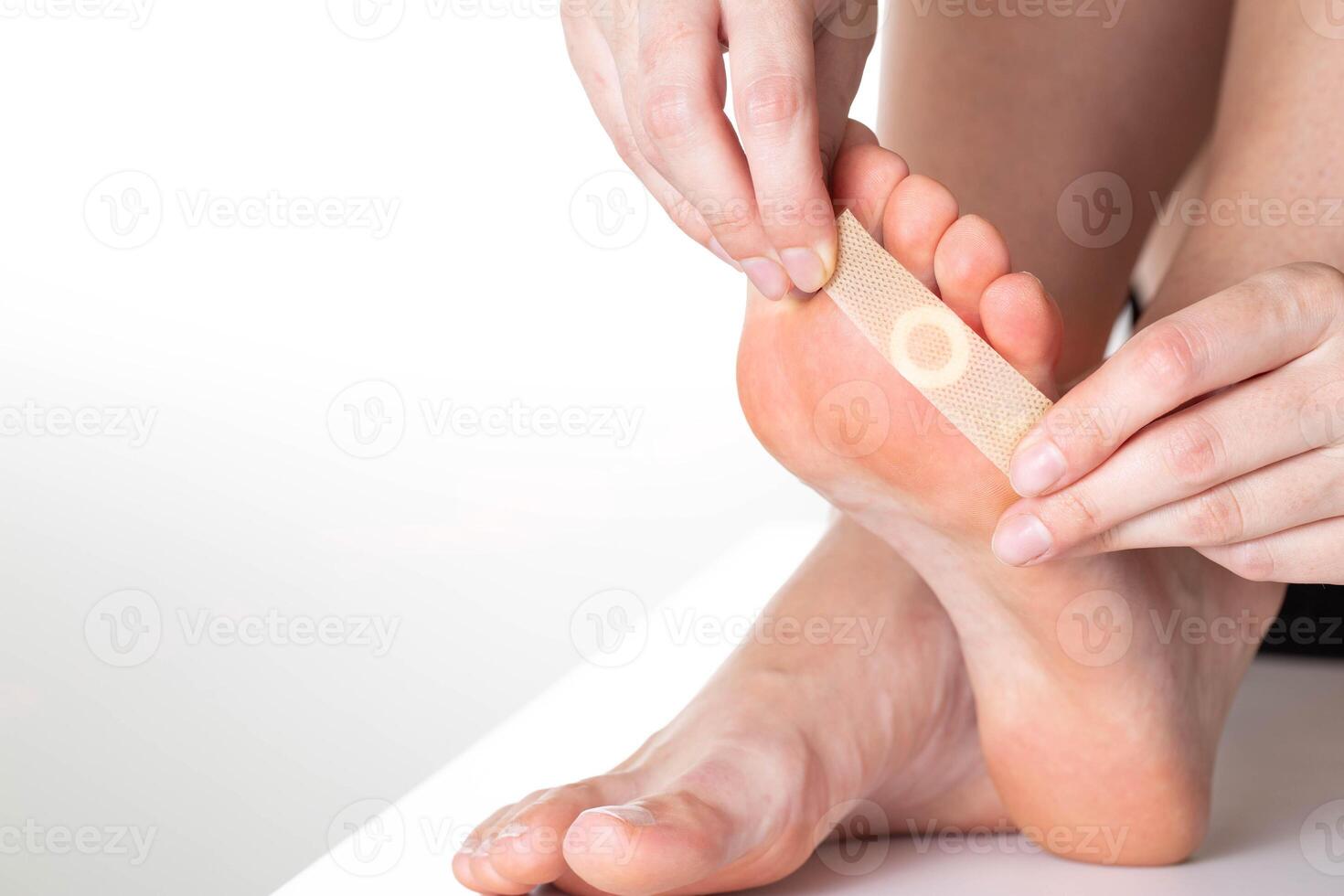 A girl sticks a medical plaster for plantar warts on her leg. Callus treatment. Copy space for text photo