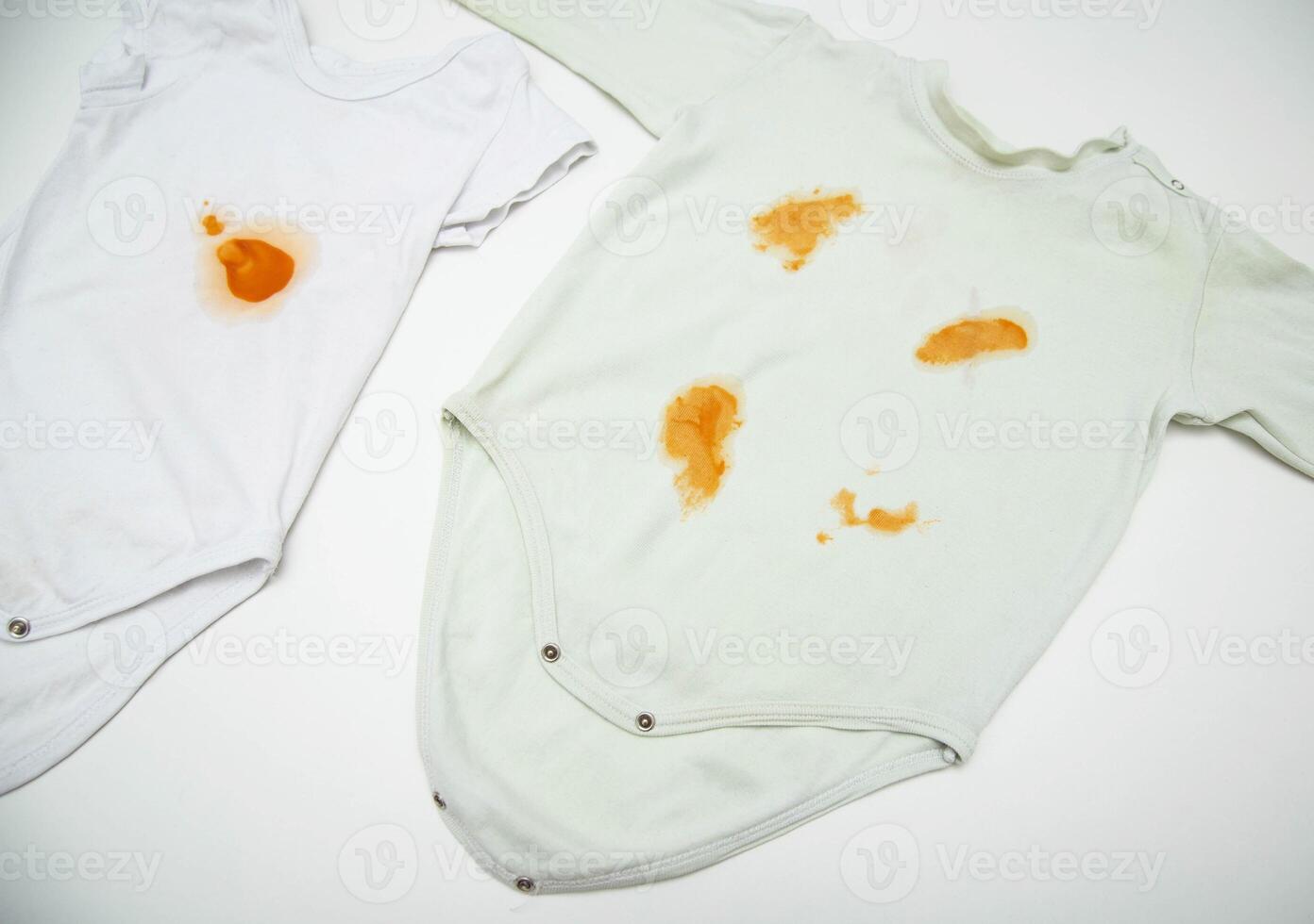 Orange stains on children's clothes from fruit puree. The concept of cleaning stains on clothes with an oxygen stain remover, close-up photo
