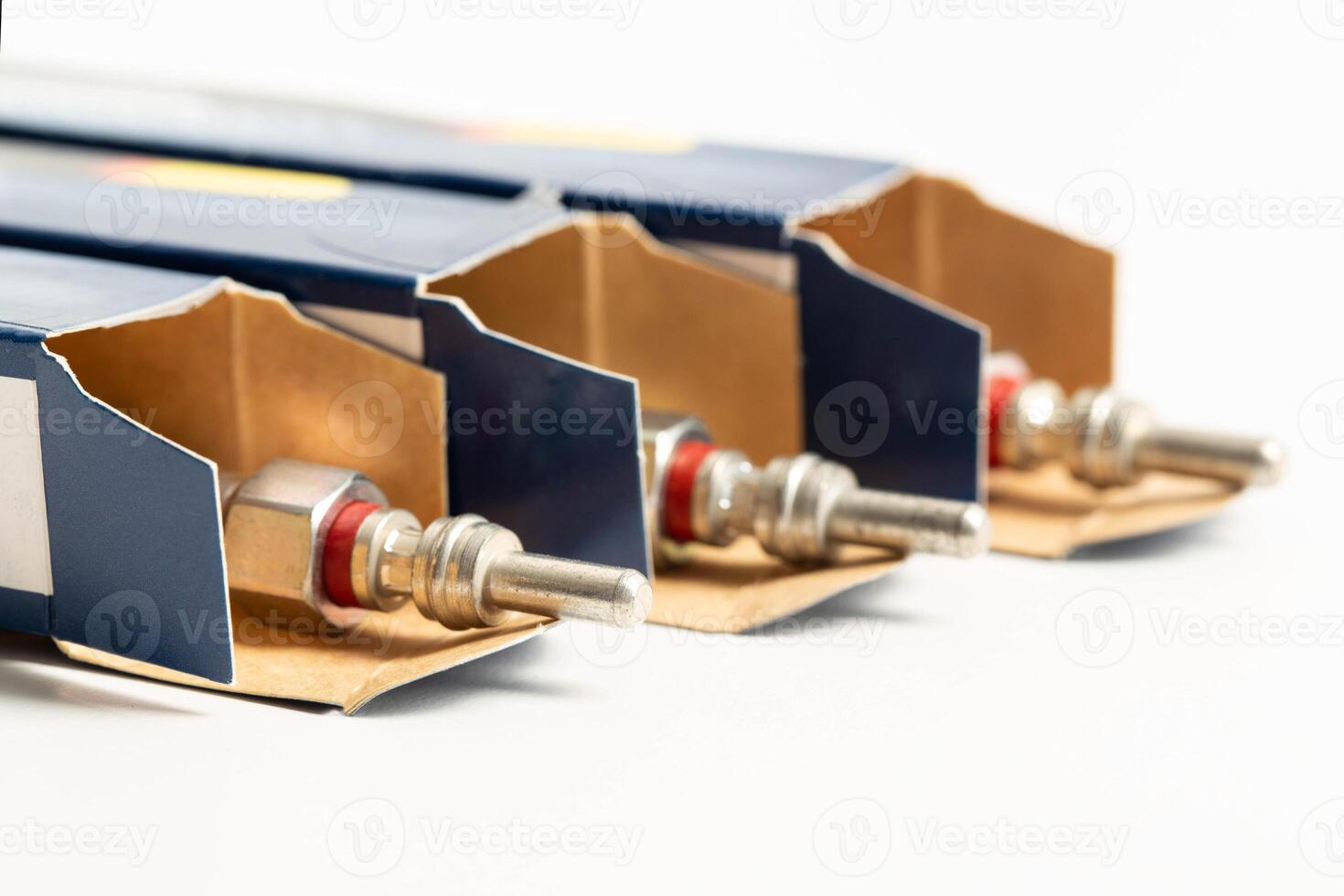 New modern ceramic glow plugs in packaging on a white background. Concept for replacing glow plugs in cold weather, close-up. Automotive part photo