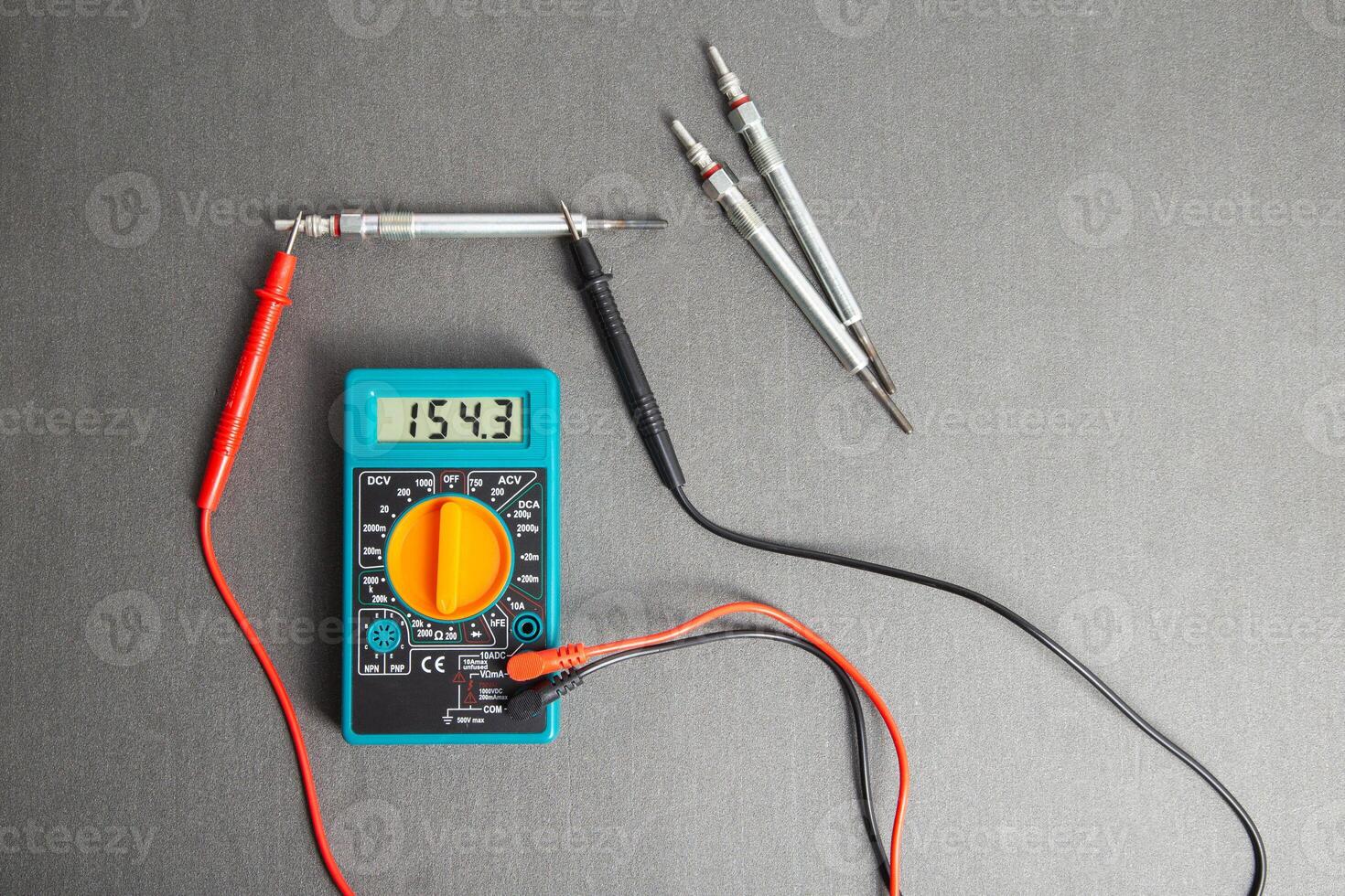 Checking the serviceability of the glow plug with a multimeter. Glow plug voltage resistance. Modern heating element, close-up photo