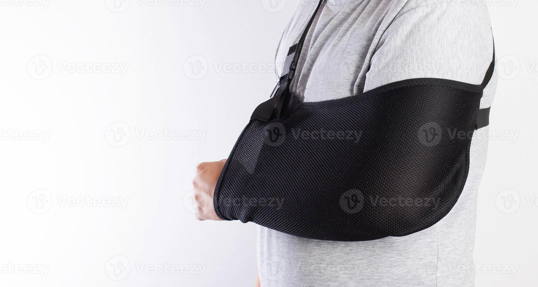 A man's arm in a black bandage for immobilization of the elbow joint after an injury. Bandage for rehabilitation after fractures of the humerus, ulna and radius. Sprain, traumatology. photo