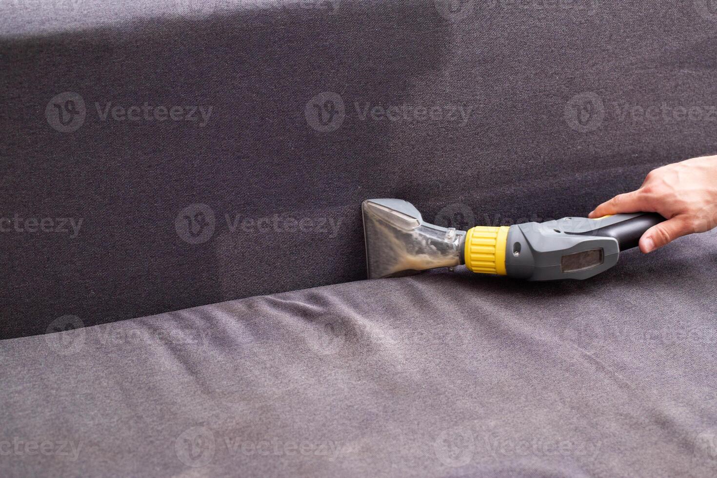 Professional dry cleaning of the sofa with a special chemical solution and a washing vacuum cleaner. Copy space for text photo