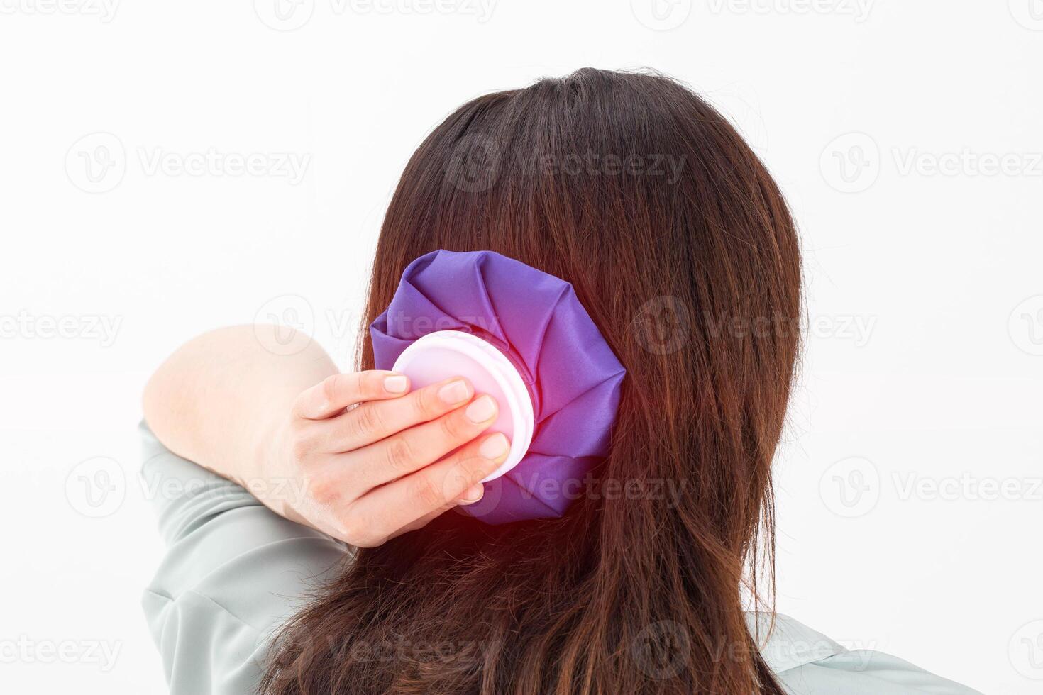 A girl holds a blue ice bag near her head to eliminate pain in the head, lowering blood pressure in case of arterial hypertension and stress, close-up photo