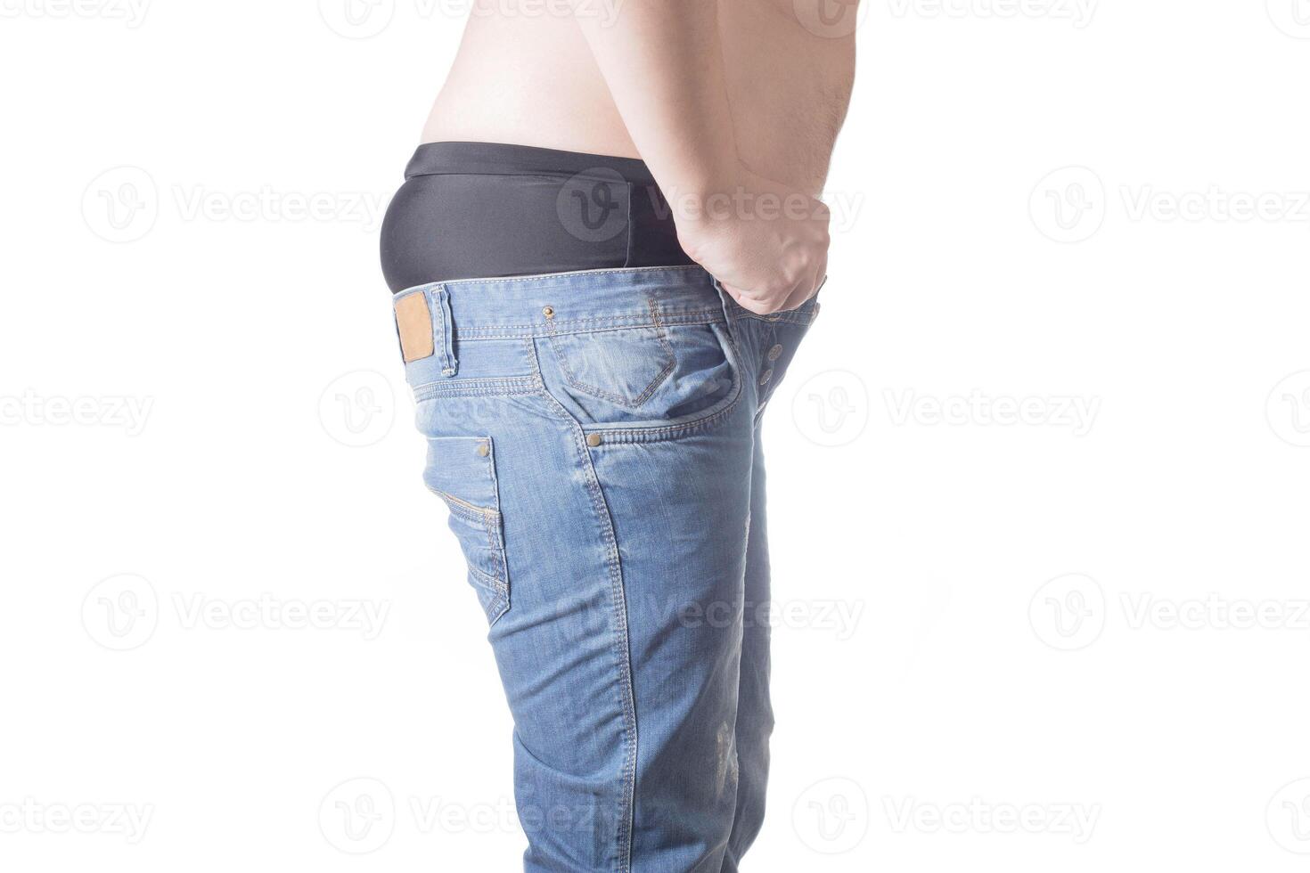 An obese man tries to put on tight little shorts on a white background. Overweight concept, wrong lifestyle photo