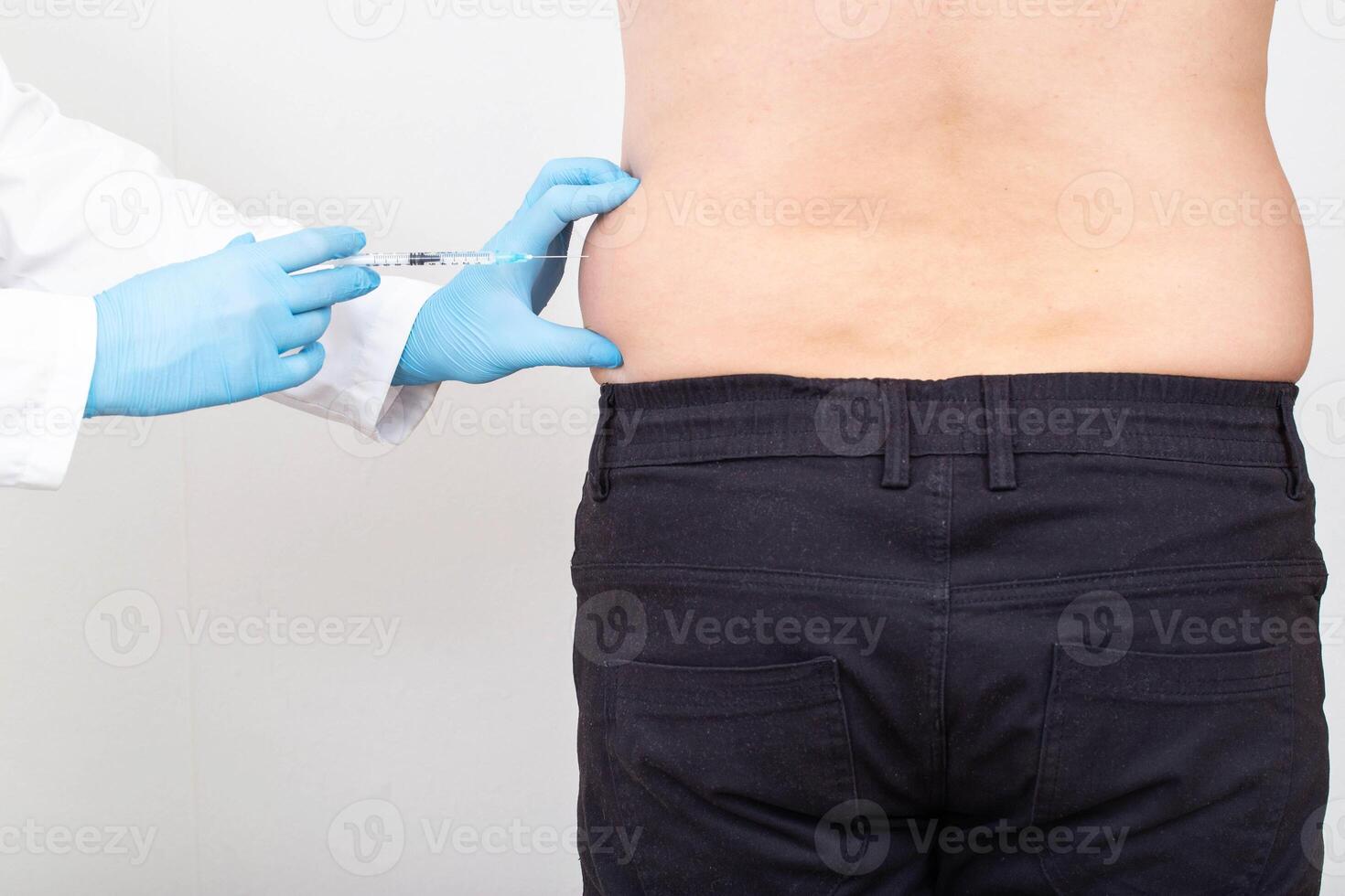 A specialist doctor makes slimming injections into the lateral fat layer. Fat burning on the sides, liposuction photo
