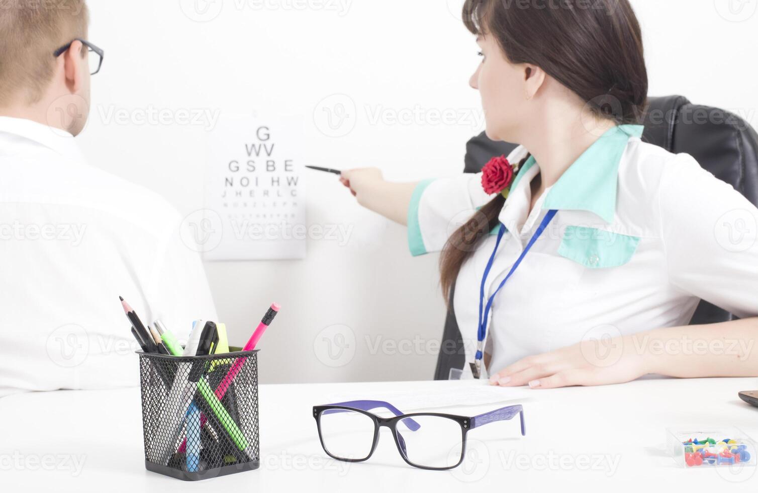 A female doctor, an ophthalmologist, checks the patient s kachets and visual acuity with glasses. Selection of eye glasses and lensmetry, background photo