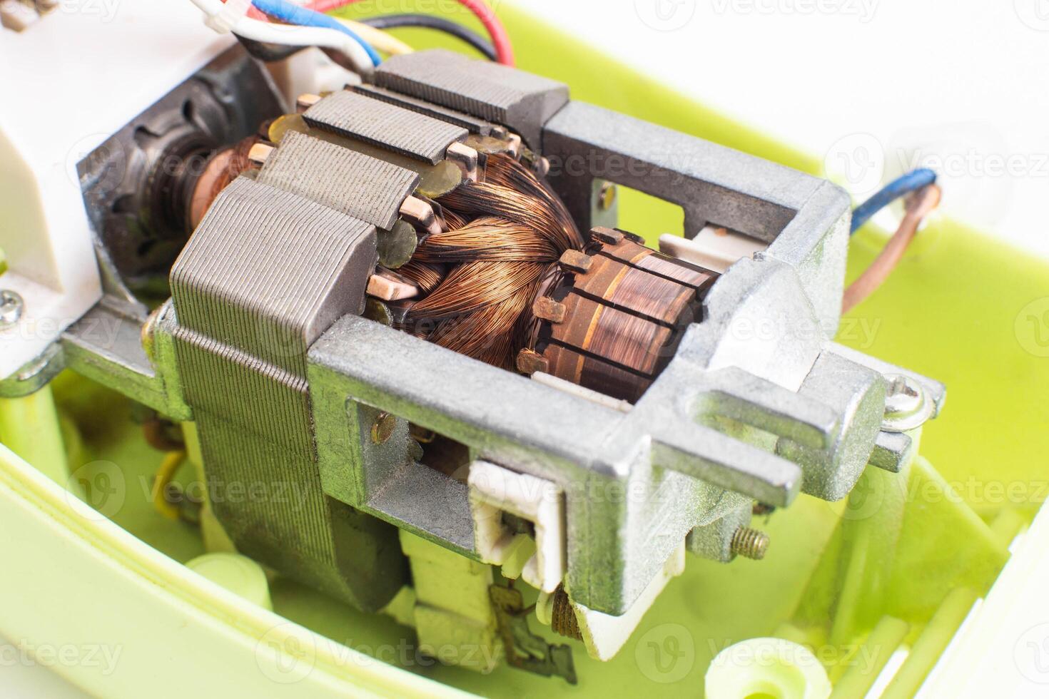 Broken electric motor in a household appliance hand mixer. Malfunction of the rotor and stator of electrical components, close-up photo