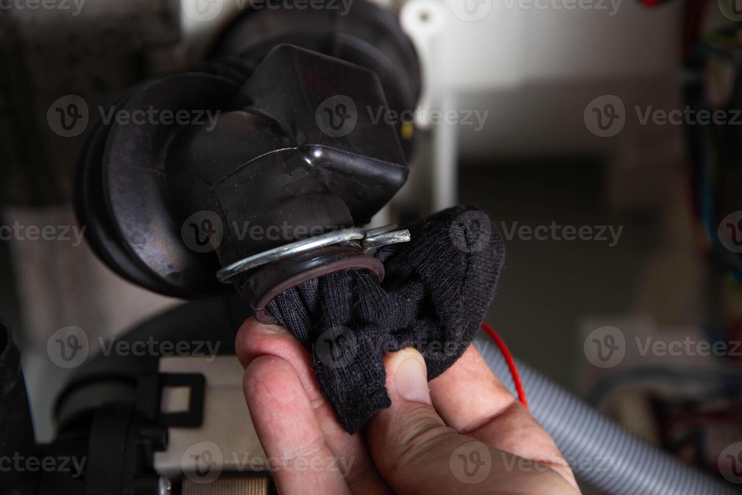 The rubber drain pipe and drain pump are clogged with clothes in the washing machine. Cleaning the water drain hole, industry photo