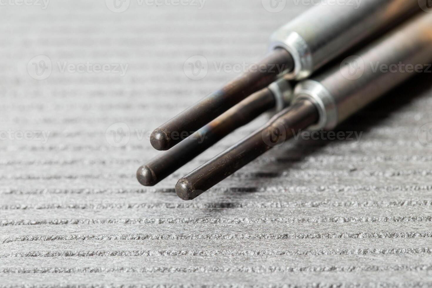 Modern rod ceramic glow plugs for easier starting of a diesel engine in cold weather on a gray background. Automotive spare part, heating element. photo