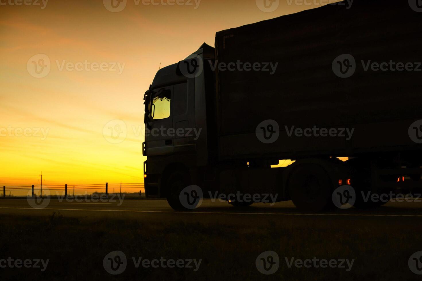 A beautiful truck with a trailer against the backdrop of an evening sunset before night. The concept of work and rest regime for truck drivers. Fine for breaching rules photo