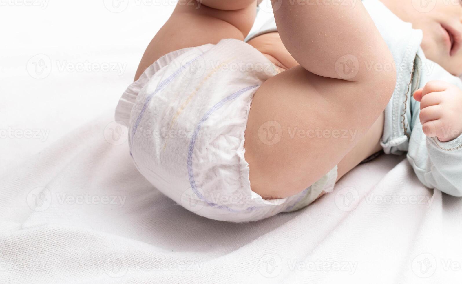 Soft and comfortable diaper for the baby who lies on the bed. Copy space for text photo