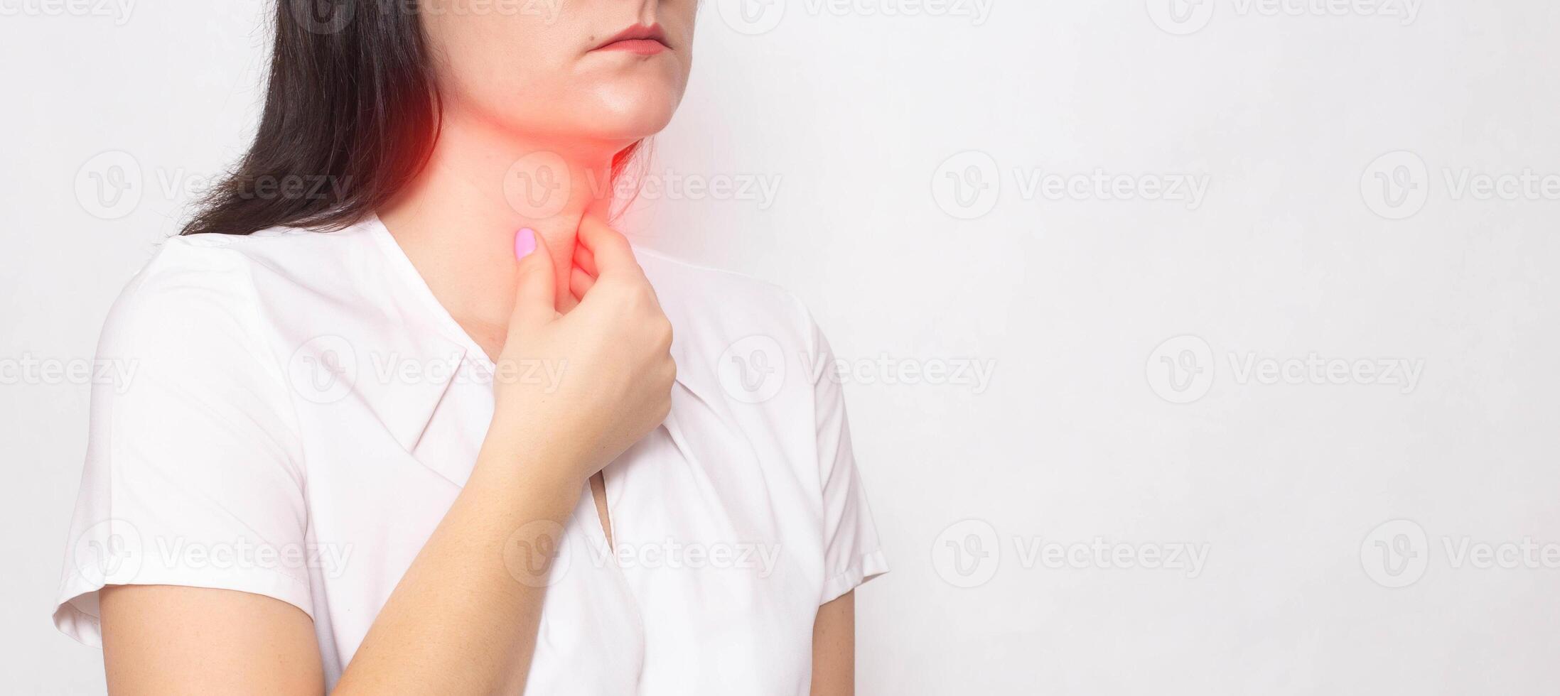The girl holds on to the sore red throat on a white background. Concept of sore throat, laryngitis and sore throat in coronavirus. Copy space for text photo