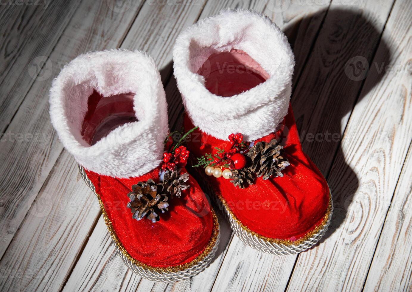 Red santa claus boots on a white wooden background. Handmade, new year 2022. Close-up photo