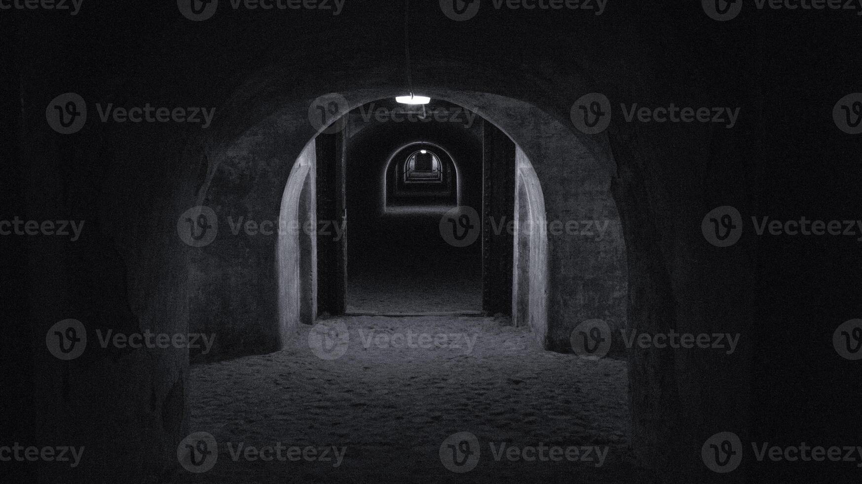 A long dark tunnel of a bomb shelter with a light at the end of the tunnel. Shelter of a bomb shelter in wartime Black and white photography photo