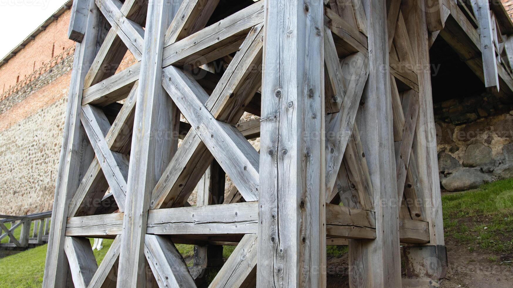 An ancient wooden staircase near a stone castle from the 14th century. photo