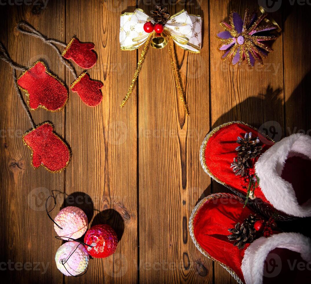 Christmas decorations, pine cones and red santa claus boots on a brown wooden background. Copy space for text, handwork photo