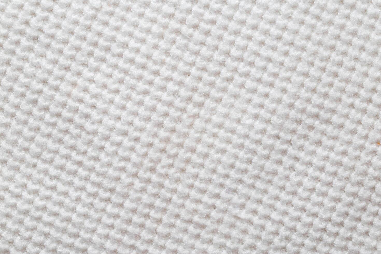 Comfortable warm knitted sweater made of white threads, background. Macro, texture photo