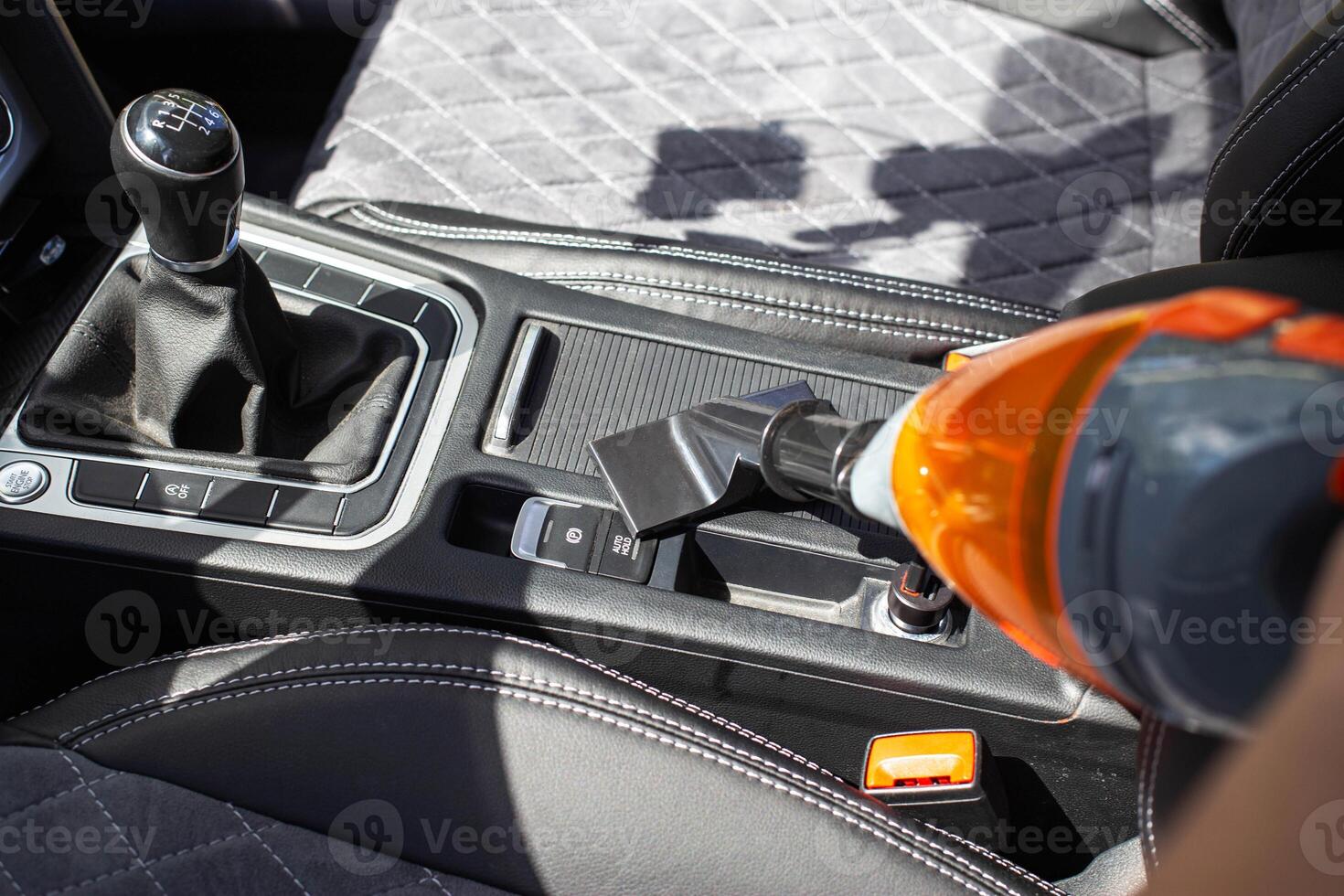 Cleaning a modern car interior with a vacuum cleaner from dirt and dust, background. Equipment photo