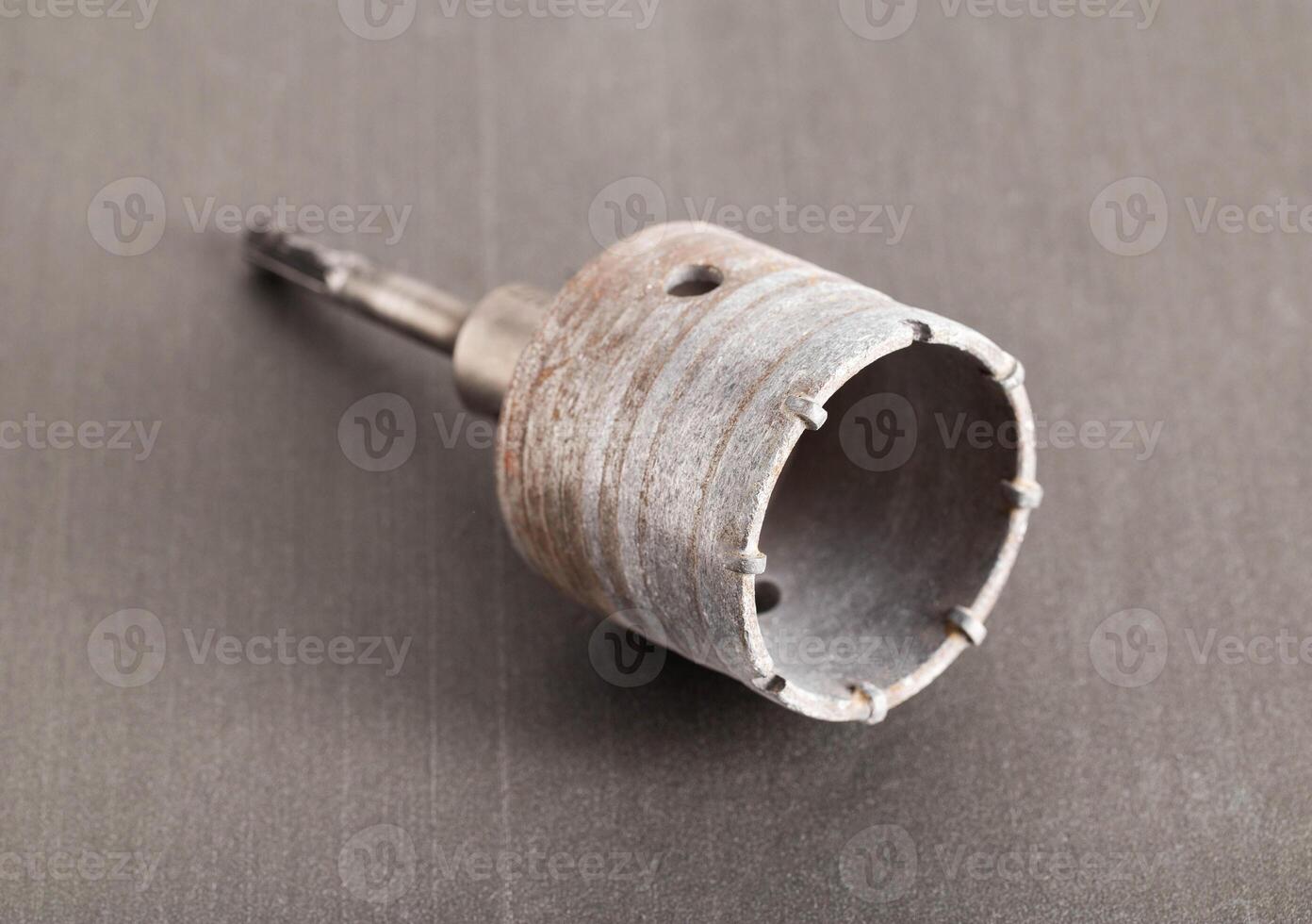 Carbide drill bit for concrete with diamond tips. Crown for socket boxes in the wall on a gray background, close-up photo