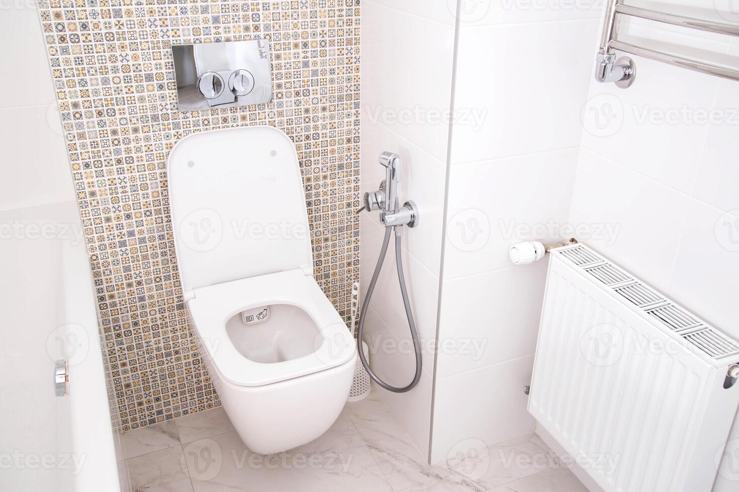 Modern wall-mounted toilet with shower for private spaces. White and clean bathroom photo