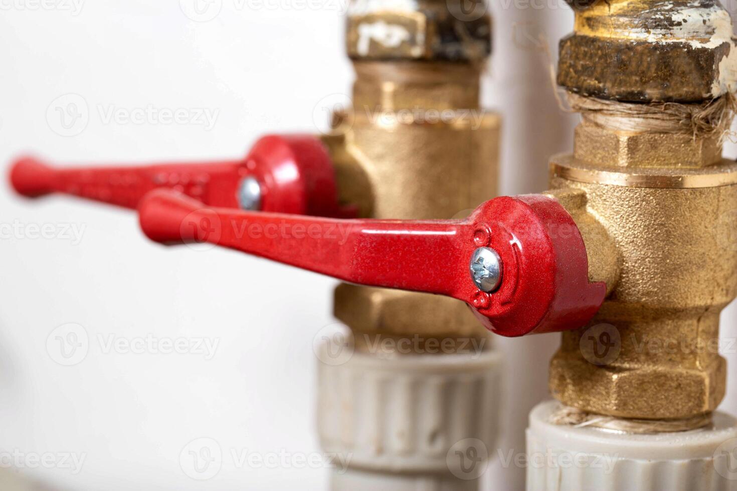 Two red water taps to turn off and turn on the water. Macro photo