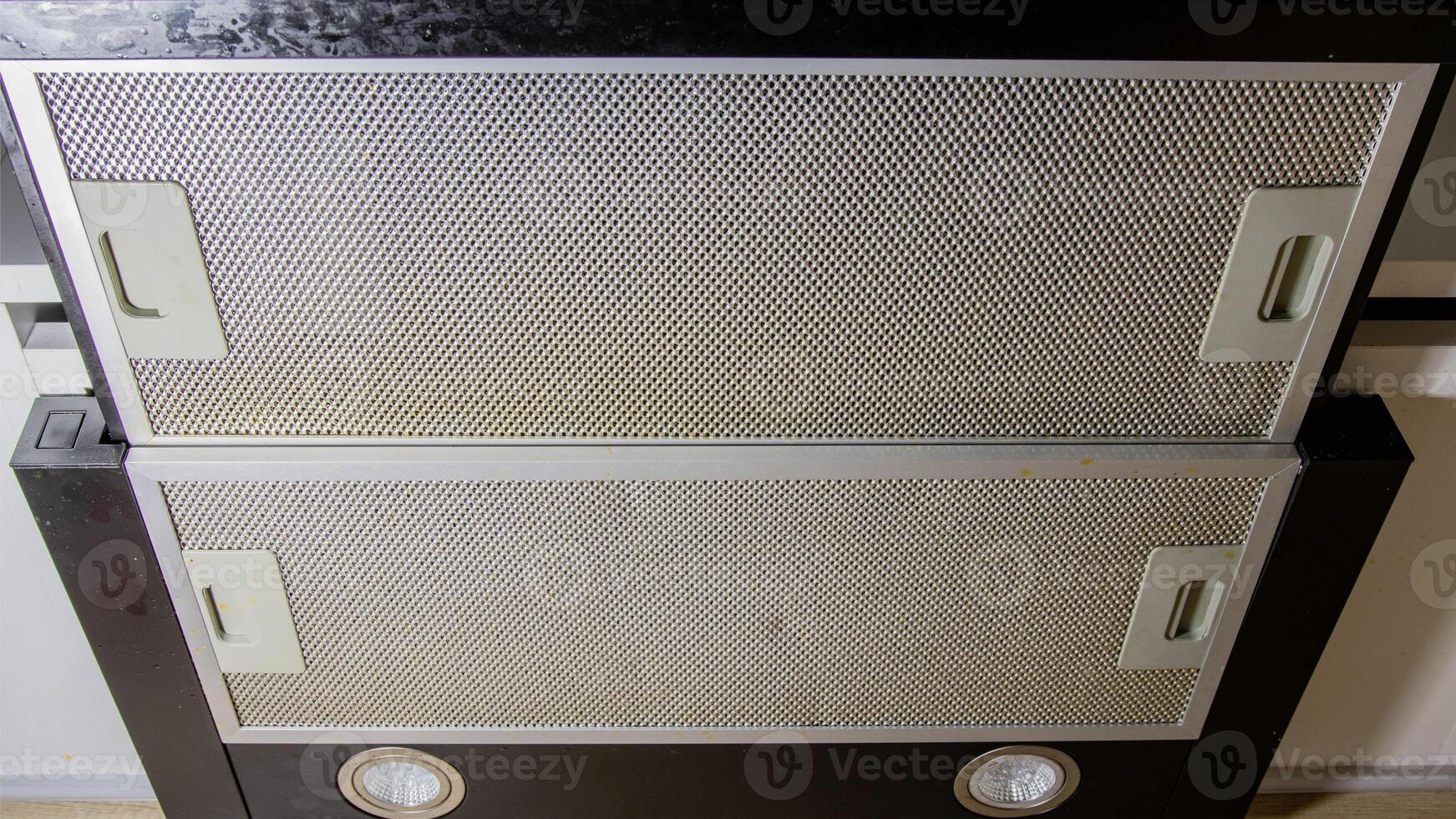 Modern kitchen hood with grease filter for air purification. Replacing the grease filter and maintaining the kitchen hood. photo