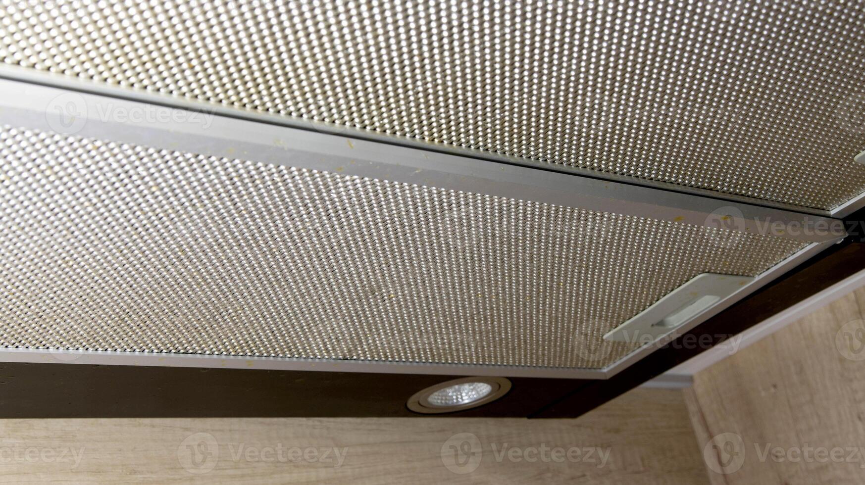 Modern kitchen hood with grease filter for air purification. Replacing the grease filter and maintaining the kitchen hood. photo