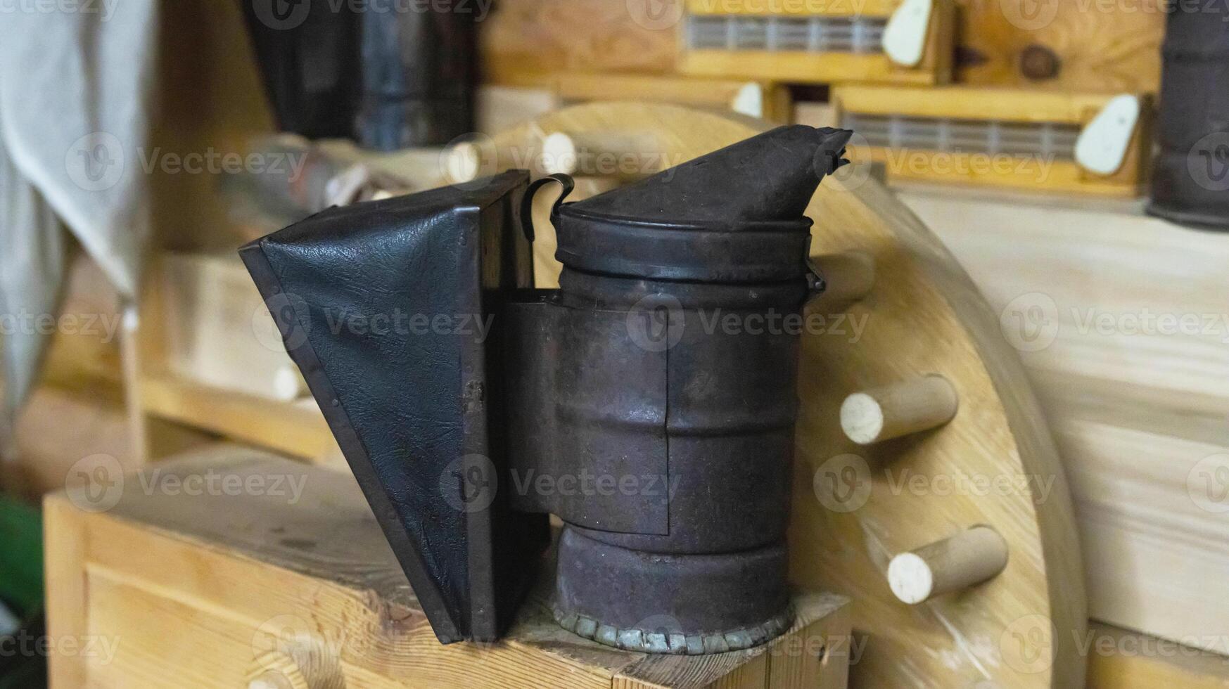 smoker for bees on a wooden background. Breeding bees and extracting honey. photo
