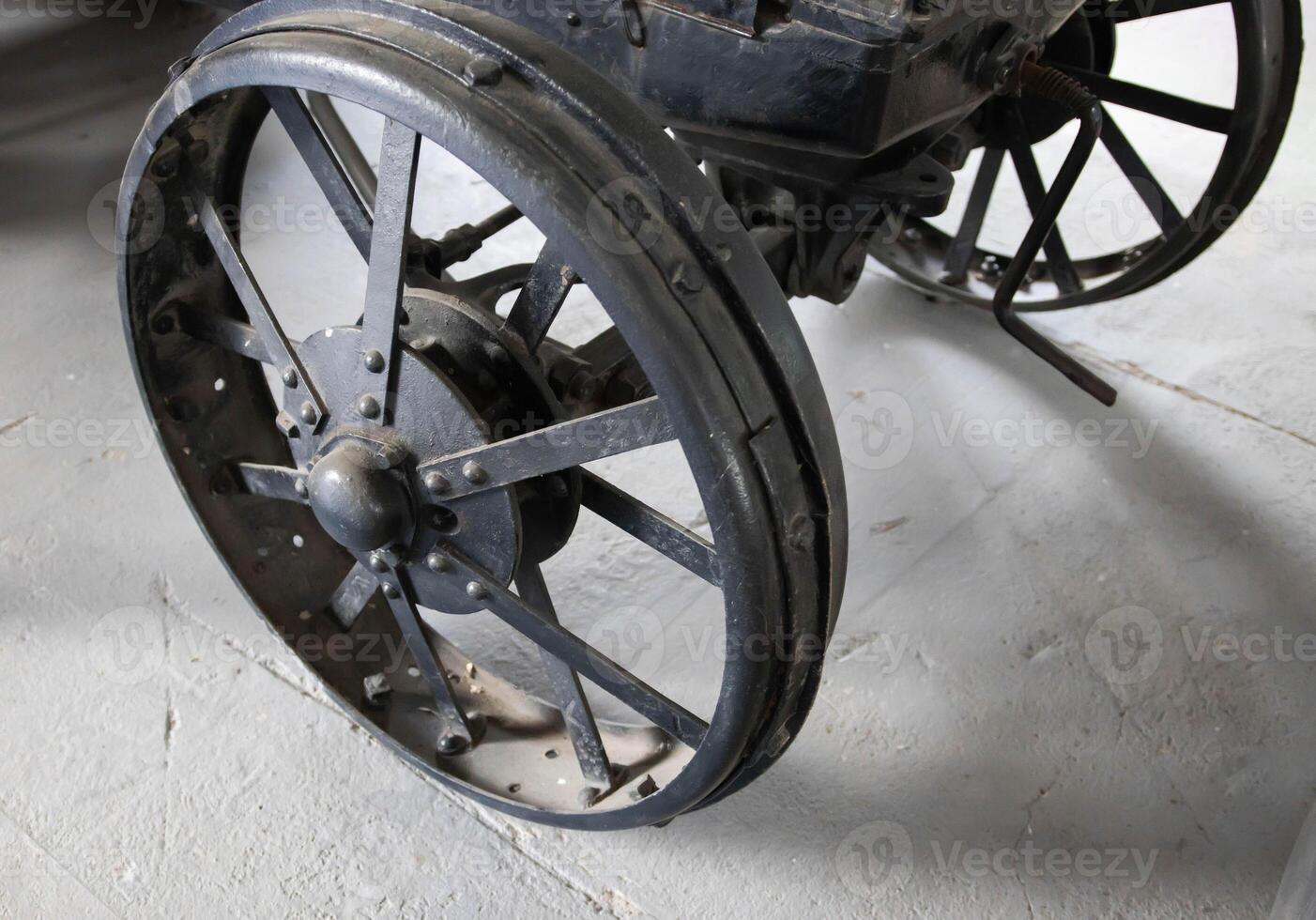 Metal wheel of the first created tractor, close-up. Retro tractor. Industry photo