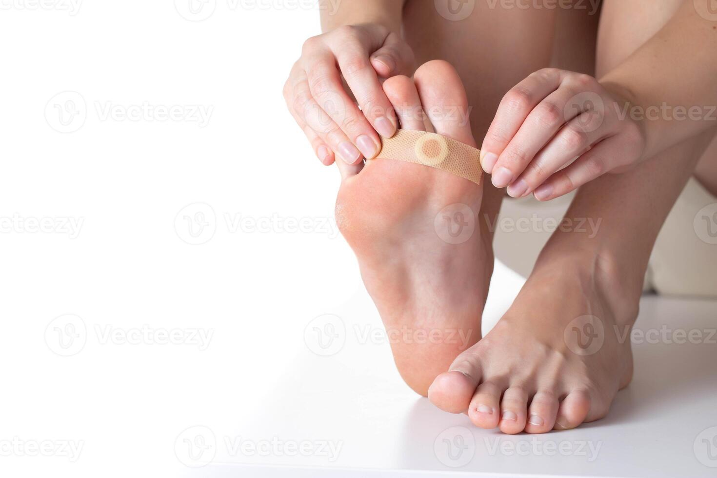 Woman sticks a medical plaster to the plantar wart of the leg to remove dead skin and calluses. Copy space for text photo