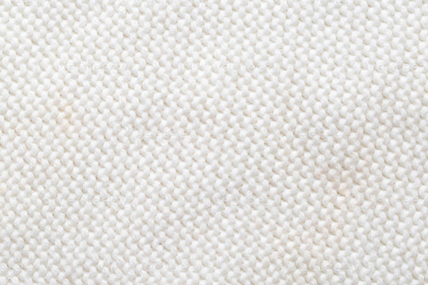 Comfortable warm knitted sweater made of white threads, background. Macro, handmade photo