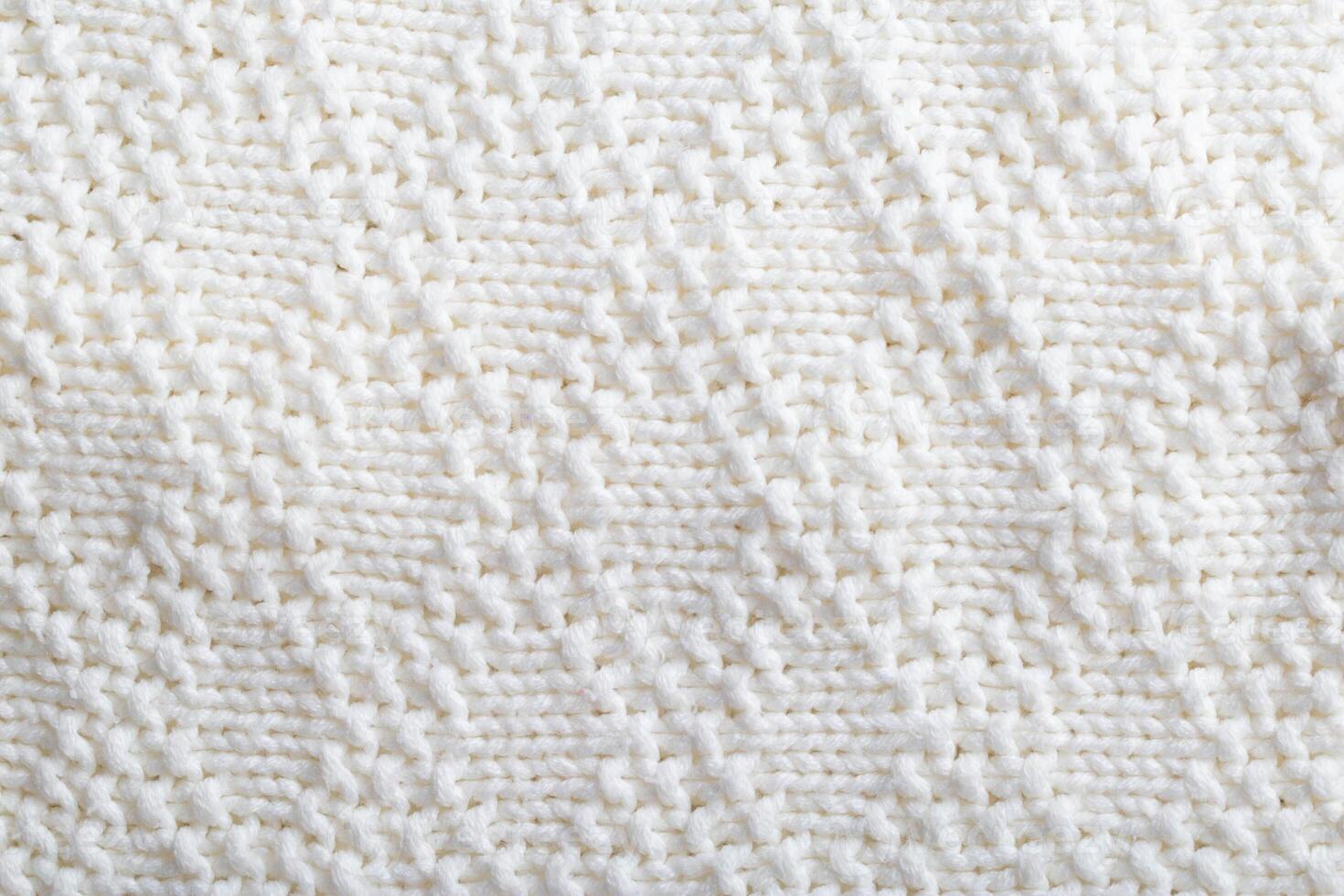 Comfortable warm knitted sweater made of white threads, background. Macro, handmade photo