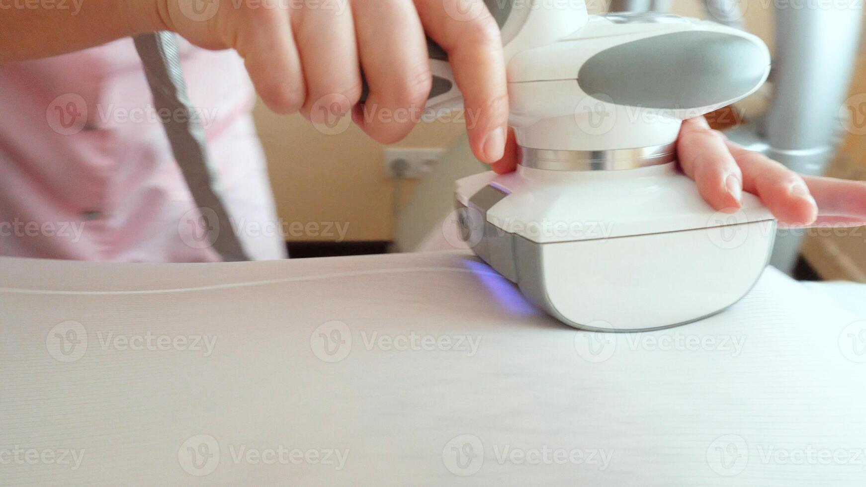 A specialist girl in a beauty salon makes a modern procedure for a fat man to reduce excess weight, restore skin density and elasticity. Apparatus massage LPG, vacuum roller machine photo