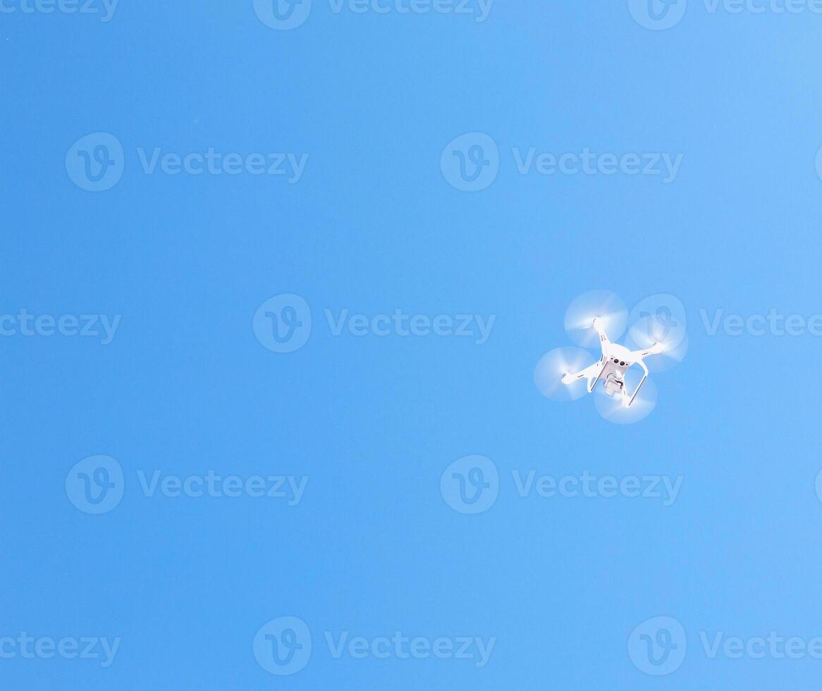 White quadcopter takes photos and shoots in the sky, copy space, drone