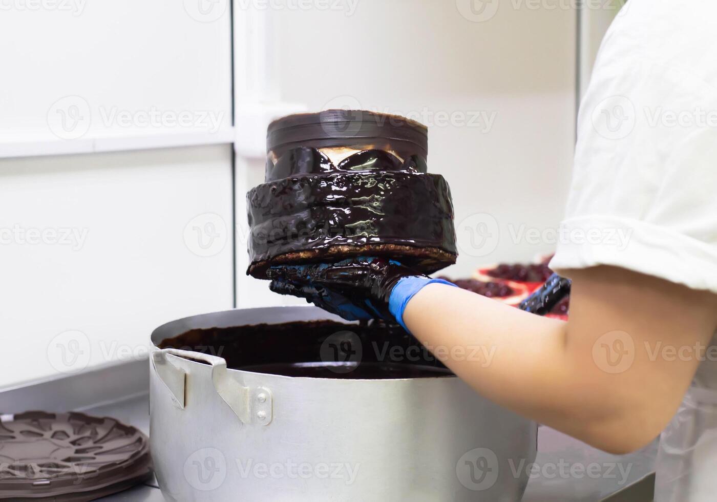 the confectioner makes a chocolate cake, pours chocolate on the biscuit cakes, handmade. Cake Making, torte photo