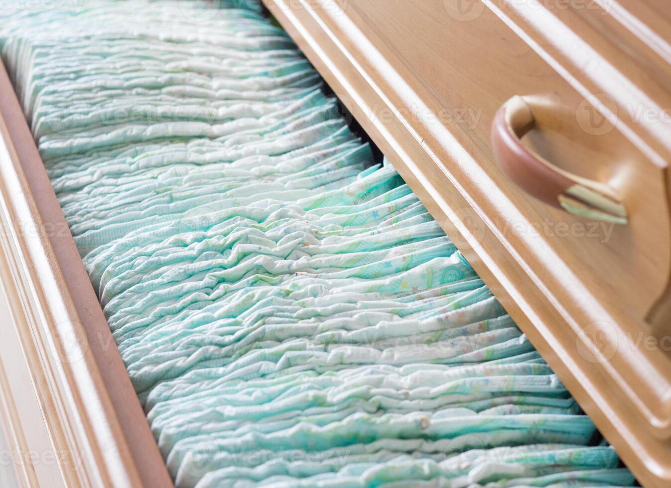 Baby diapers in the dresser, scarves and diapers photo
