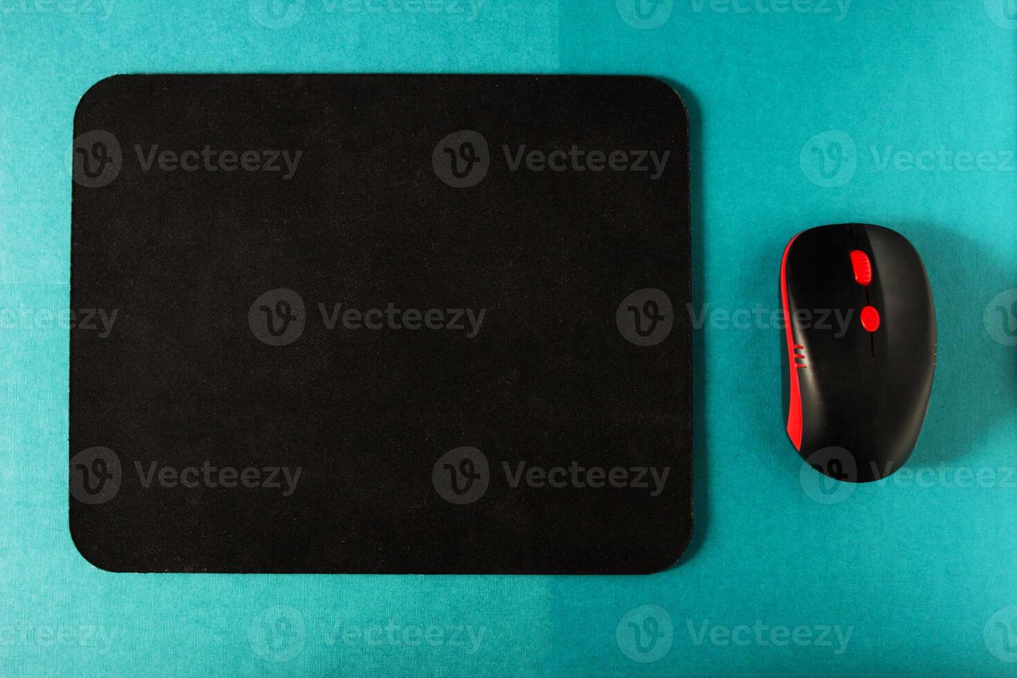 Computer mat and computer mouse on a turquoise background, close-up, instrument photo