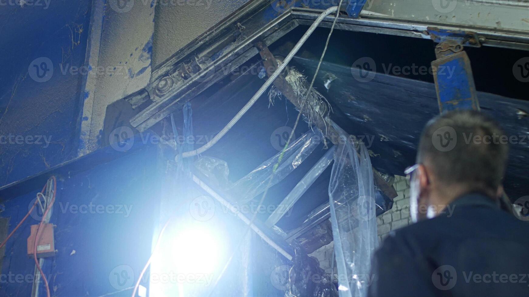 The worker looks at the conveyor belt in garbage recycling company photo