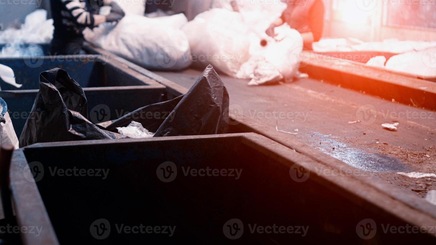 Workers select and sort garbage that travels on a conveyor belt in a waste recycling plant, environmental photo
