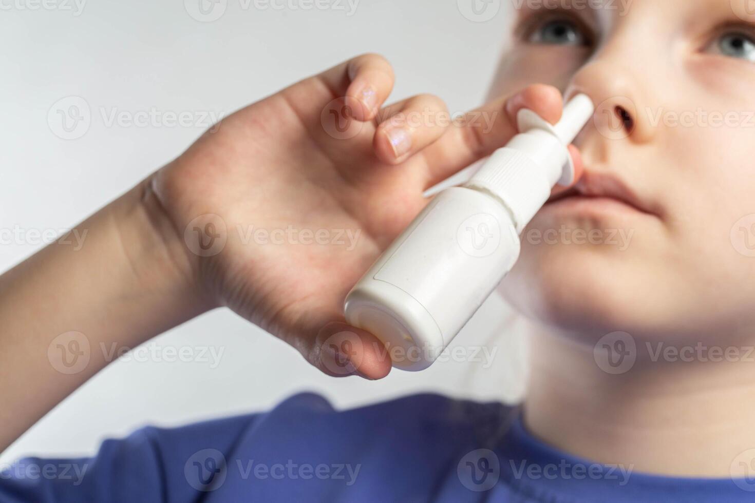 A girl sprays a spray against runny nose and nasal congestion into her sinuses. Treatment of sinusitis and sinusitis, antimicrobial spray, close-up photo