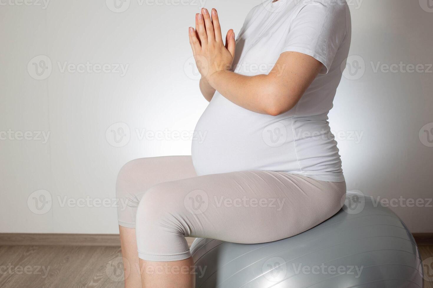 Relaxation and meditation for a pregnant girl on a fitball ball on a white background. Women Health. Copy space for text photo