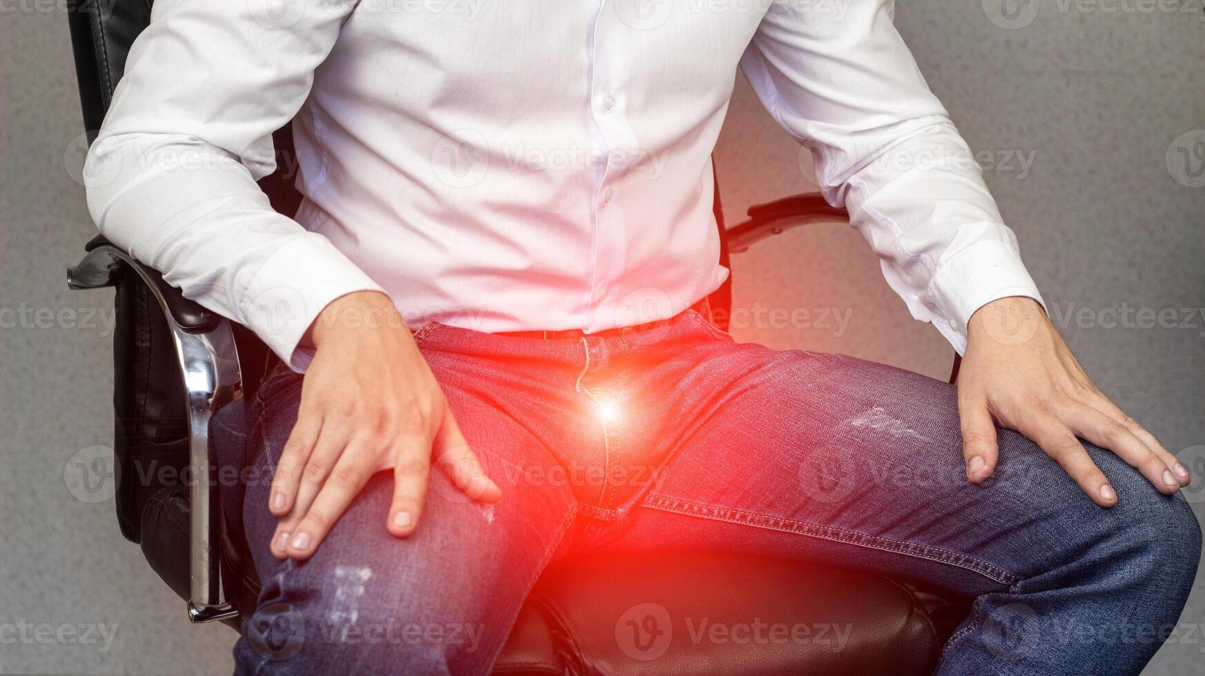 A man sits in an office chair, sore groin, crotch, prostatitis, close-up photo