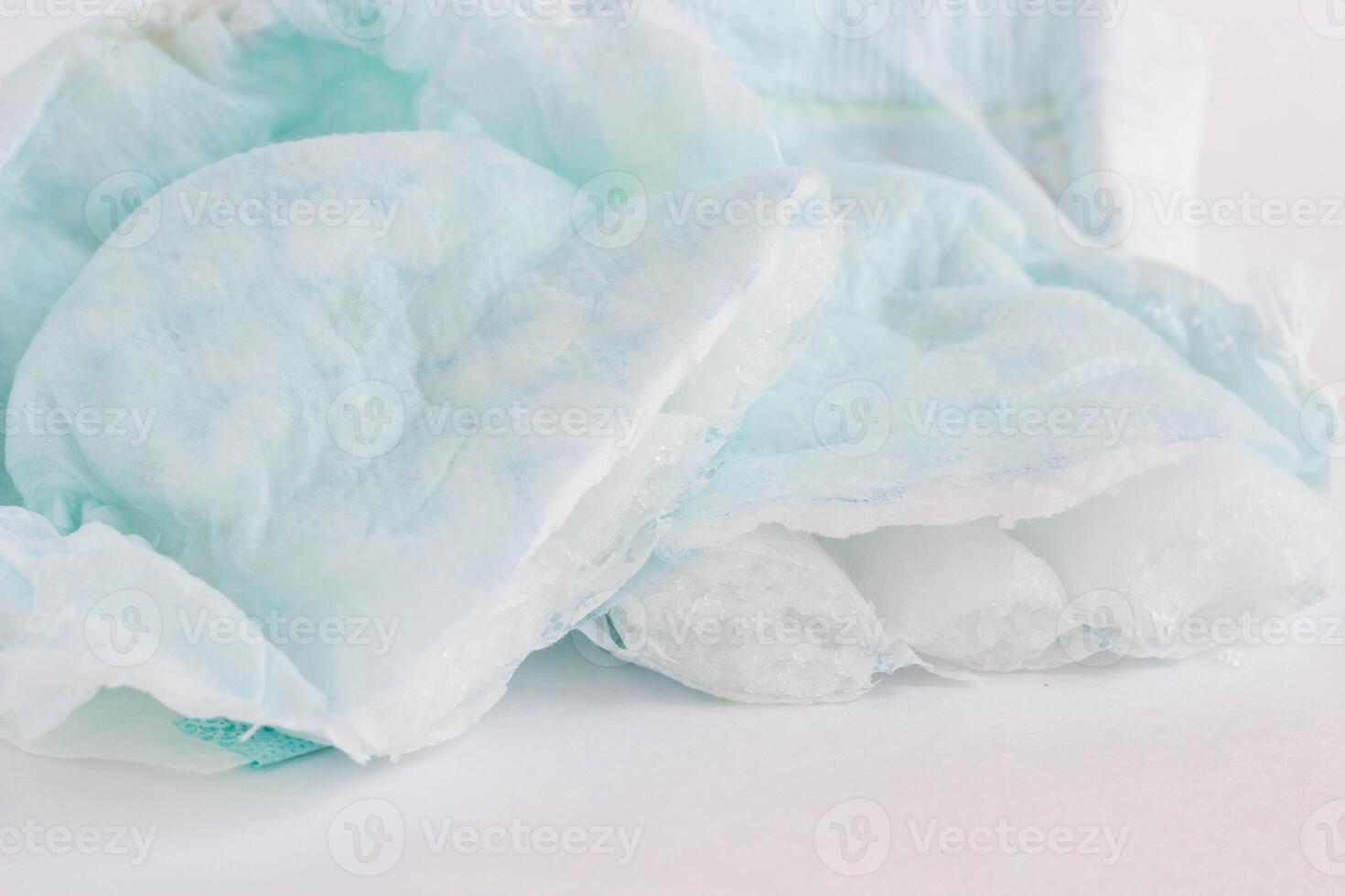 Baby diaper cut in half on white background, close-up photo