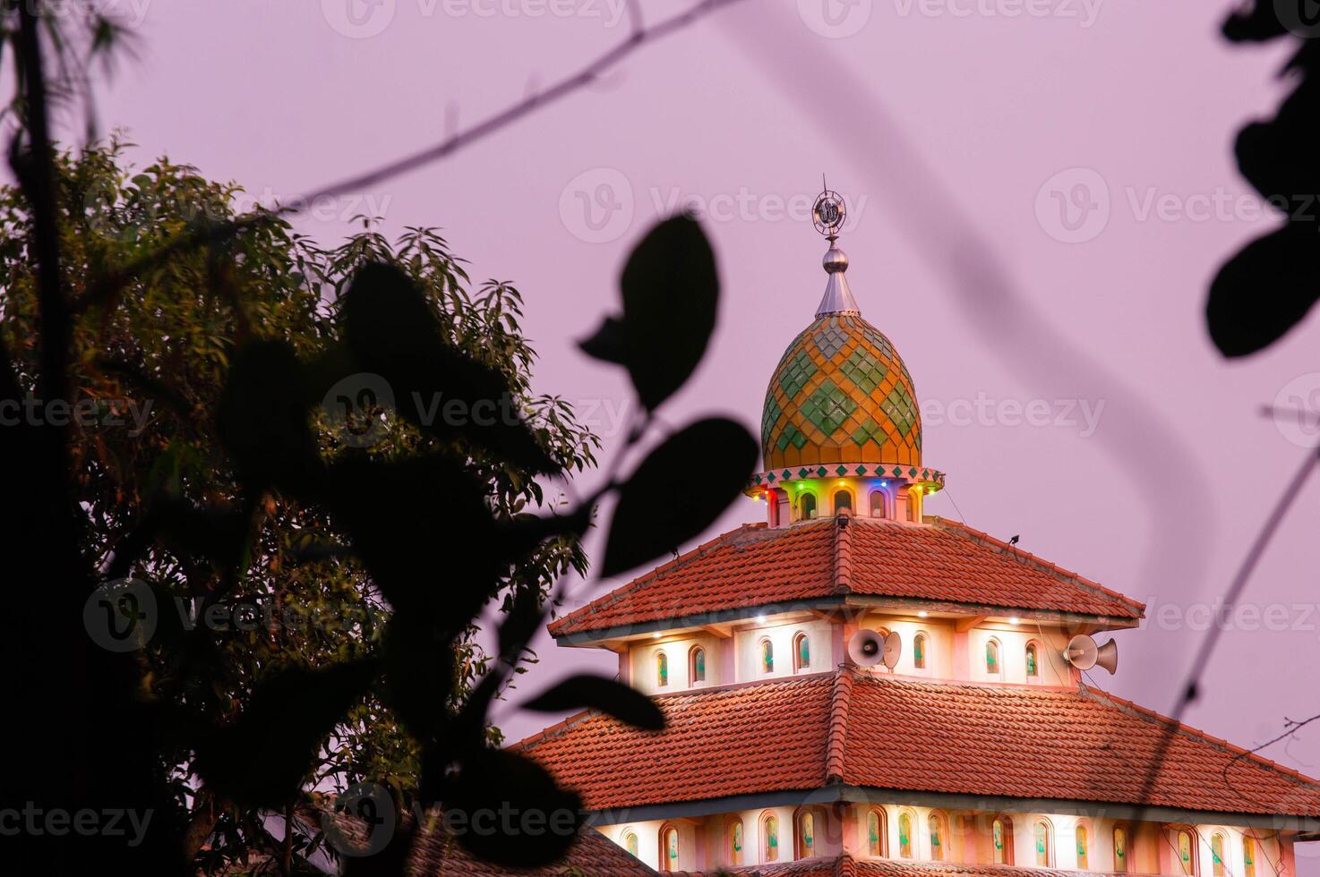 view of the mosque before sunset with the lights on photo