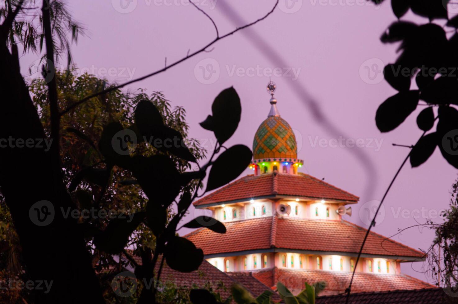 view of the mosque before sunset with the lights on photo